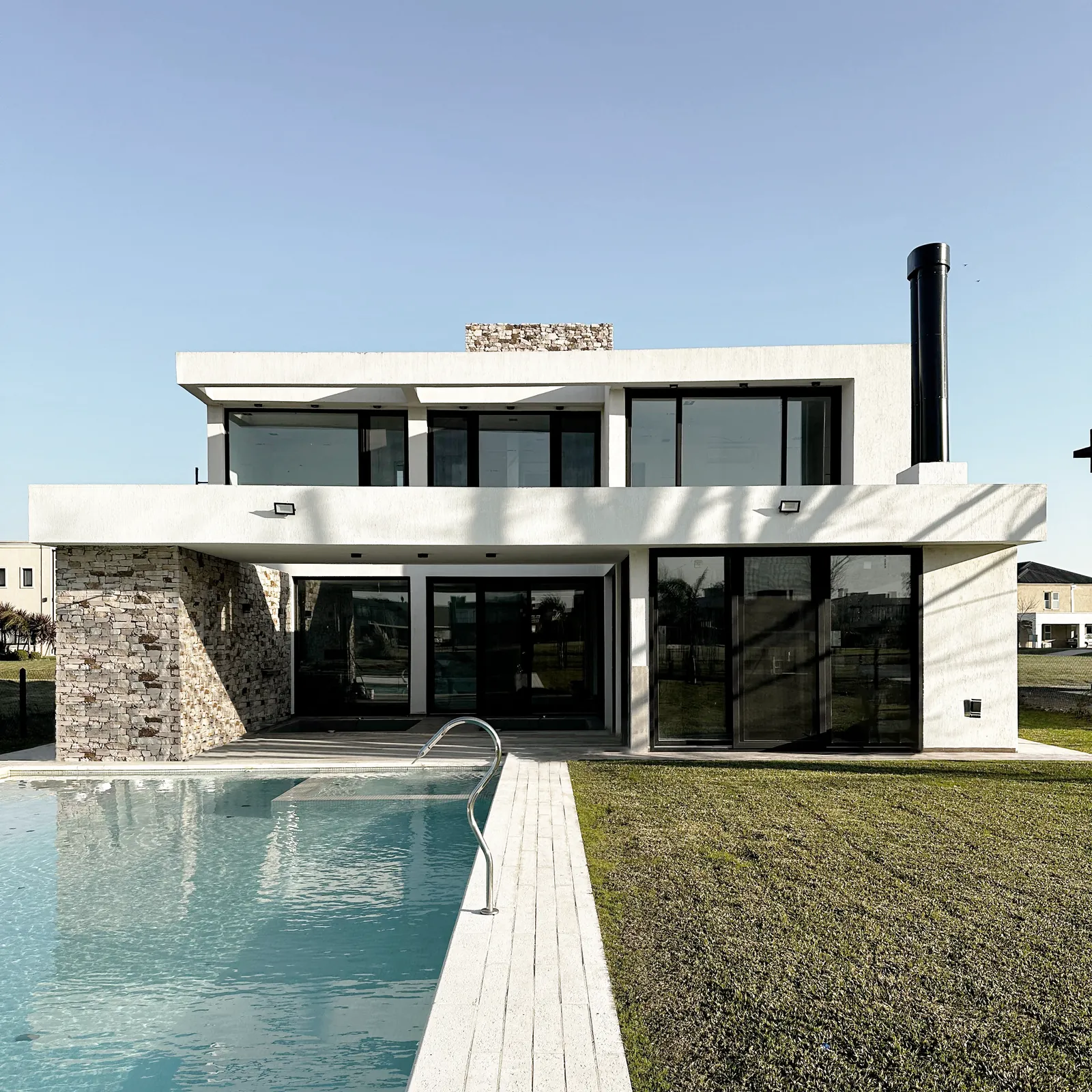 Casa F en Terralagos: contrafrente con piscina y jardín